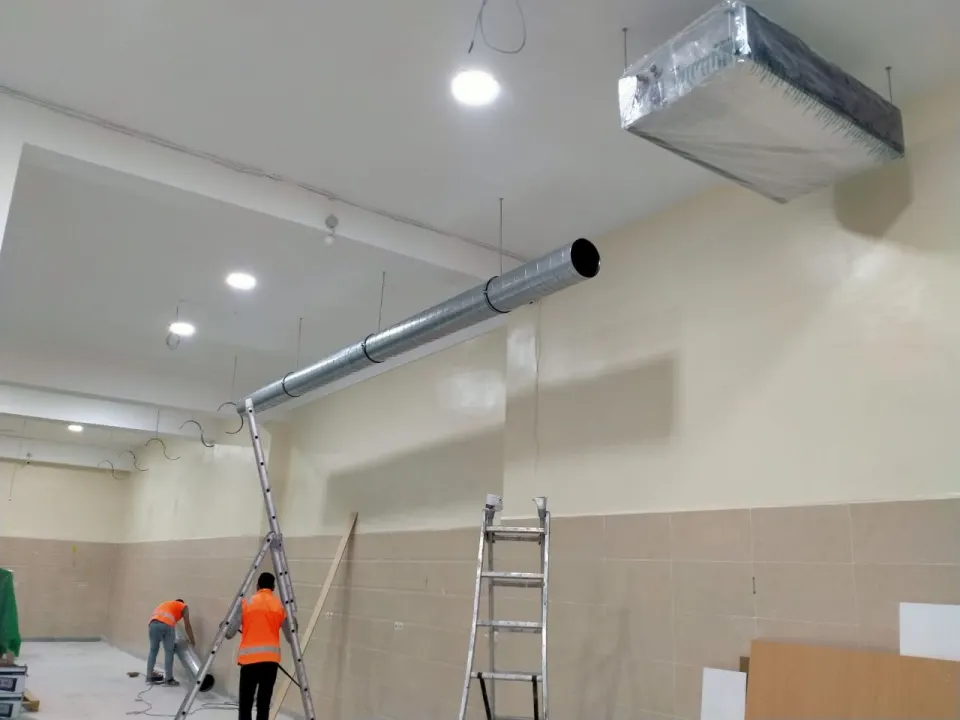 Pose de gaines de ventilation au plafond d'un local commercial